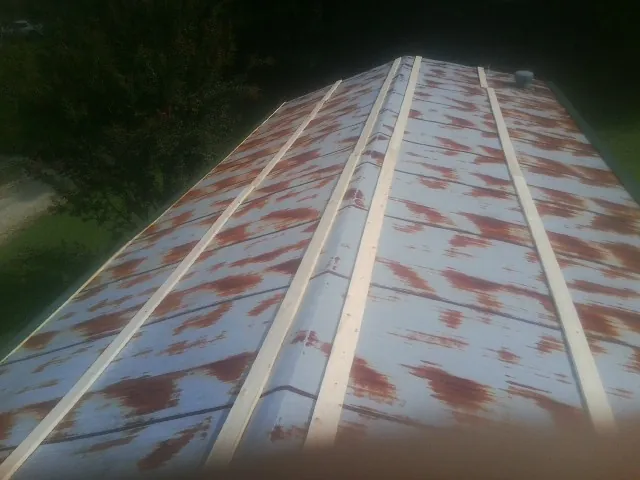 Rusted metal roof panels with new wood purlins before replacement — Storm Damage Roof Repair in Armington by Roofing Brothers