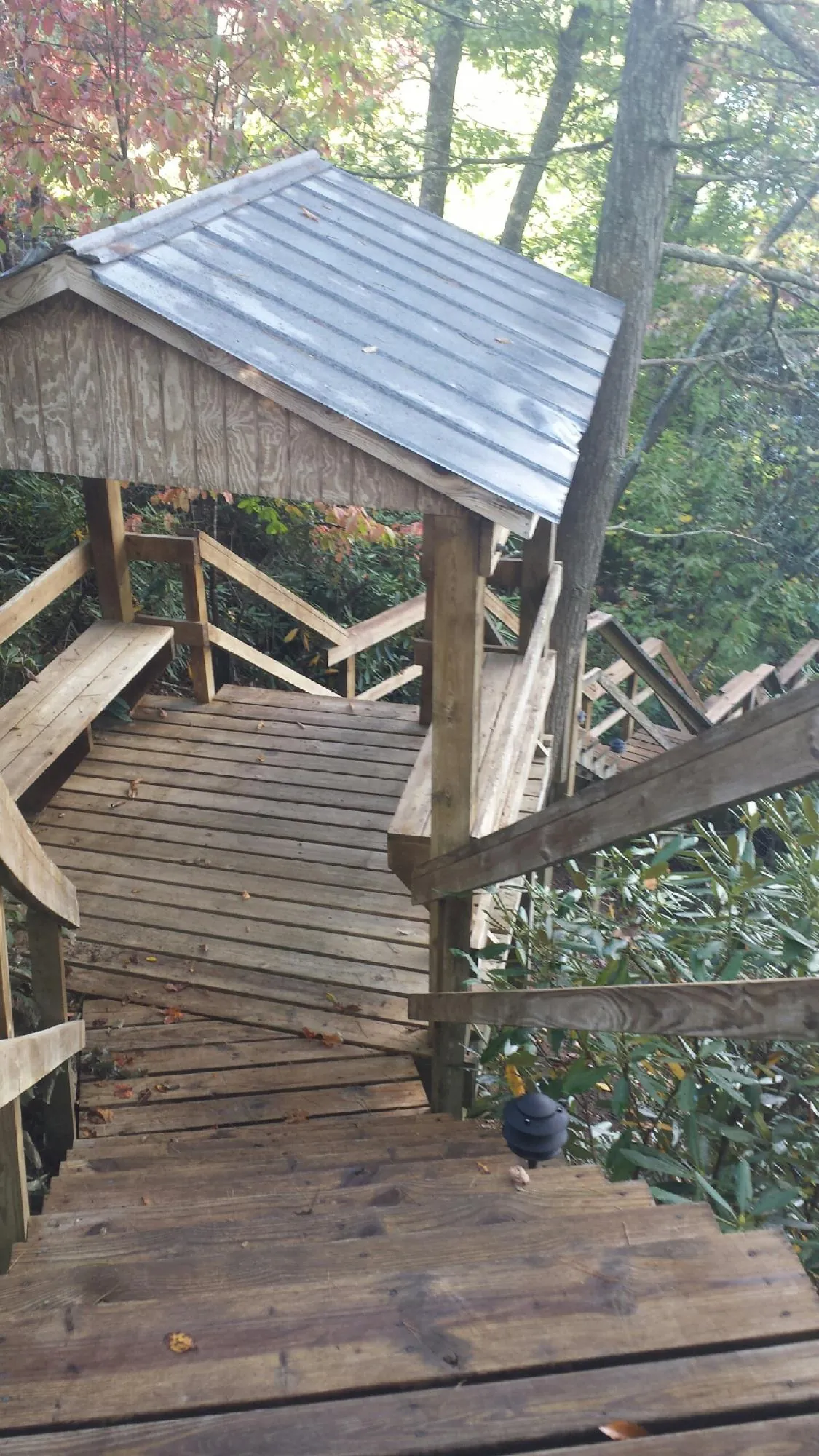 Metal roofed shelter over wooden steps on a wooded walkway — Skylight Repair & Installation work by our crew in Armington