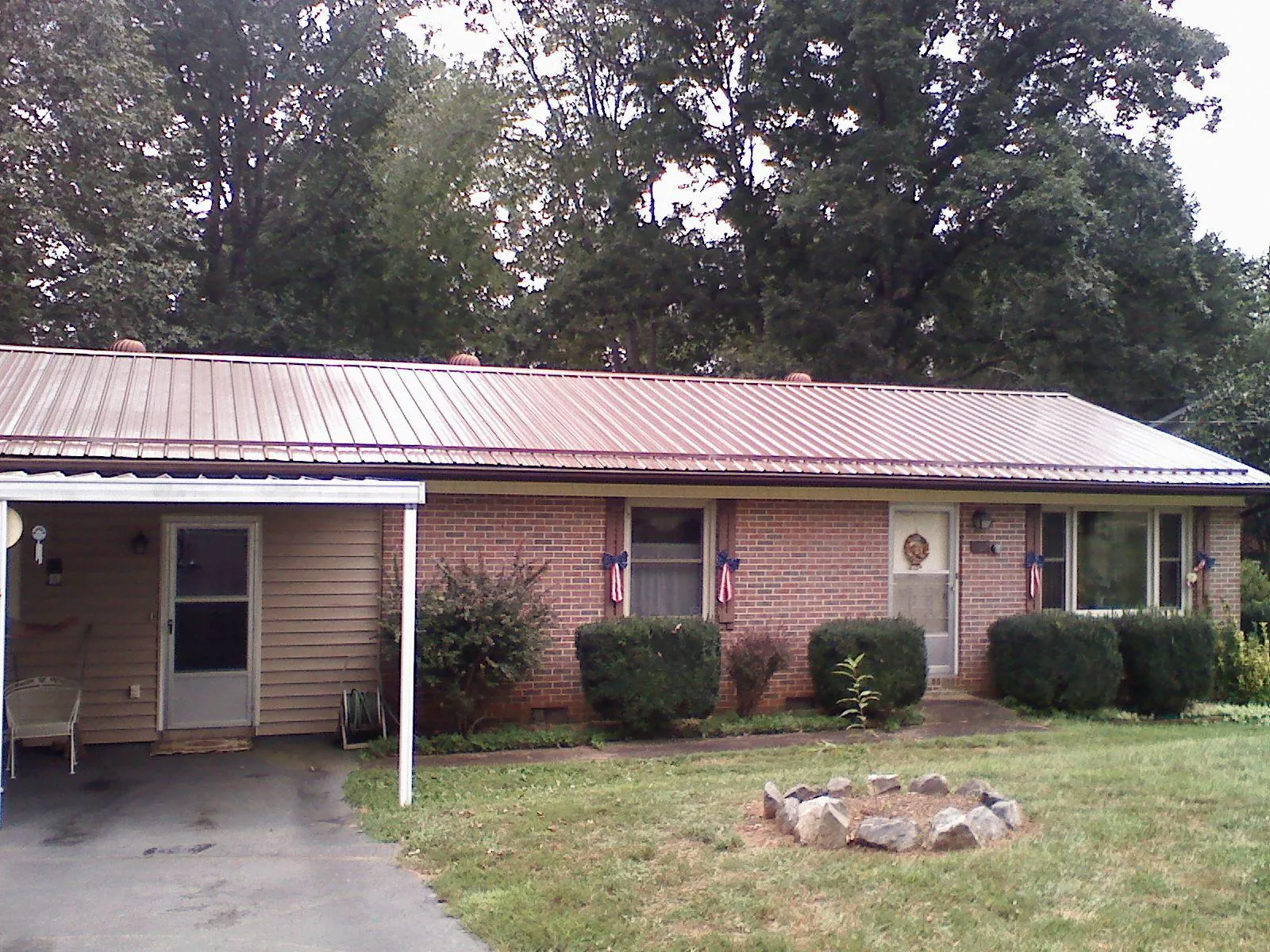 Bronze metal roof and carport on a brick ranch home — Roof Repair work by our crew in Armington